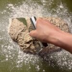 Bolledej på et bord skæres over med skarp dejskraber